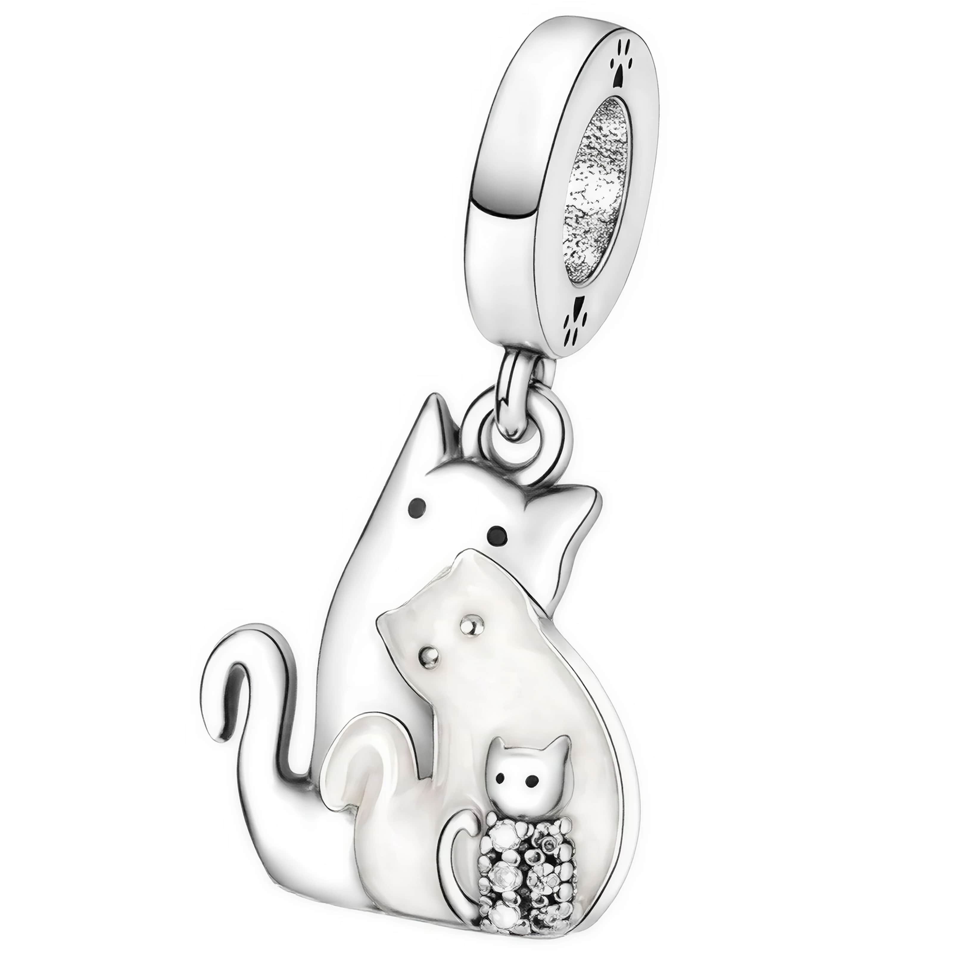 Zawieszka charms przedstawiająca trzy stylizowane koty, wykonana z metalu o srebrnym połysku. Górna część zawieszki ma okrągły kształt z wyciętymi wzorami przypominającymi łapki.