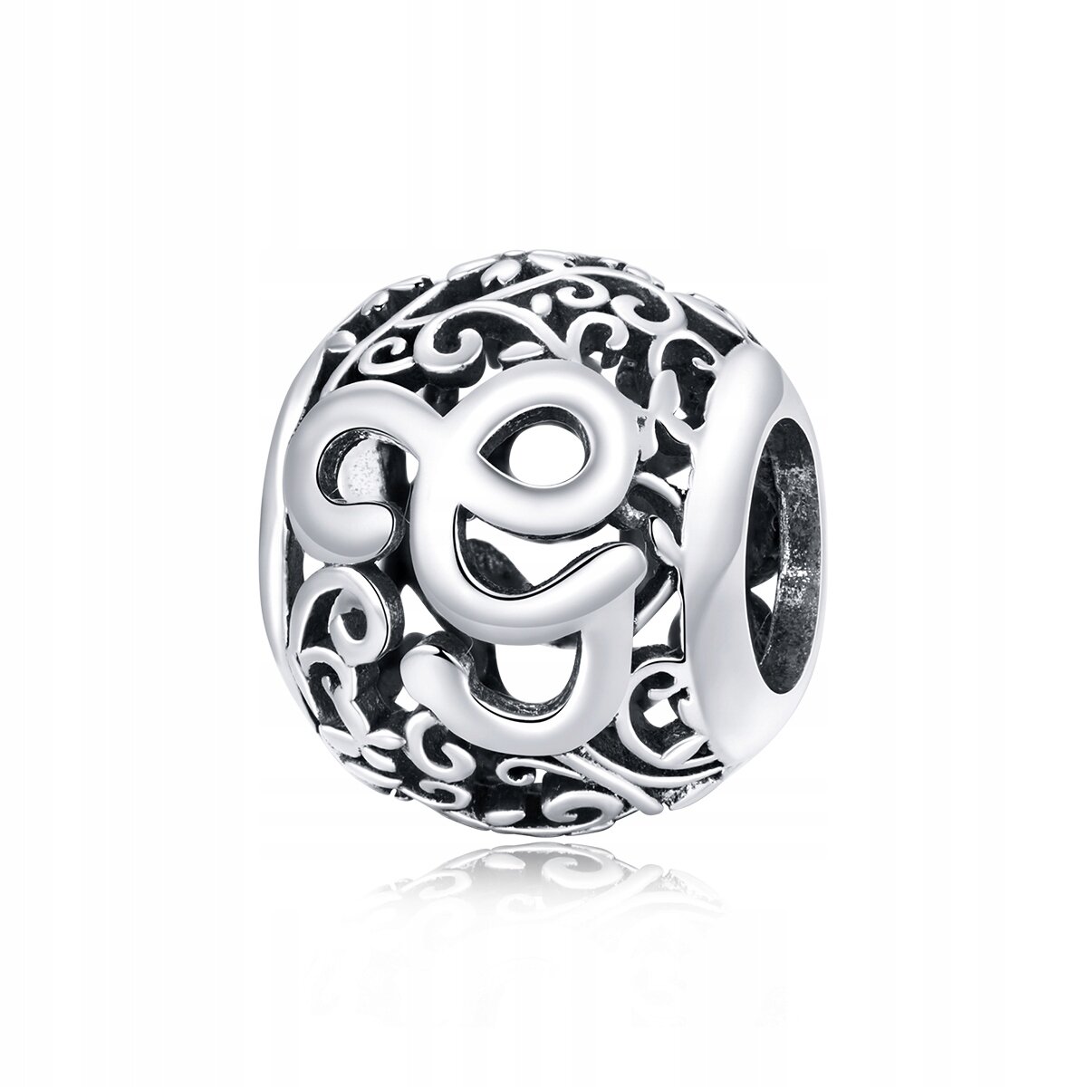Srebrna zawieszka charms z literą \'G\' w ozdobnym, ażurowym wzorze. Wykonana z metalu o wysokim połysku.
