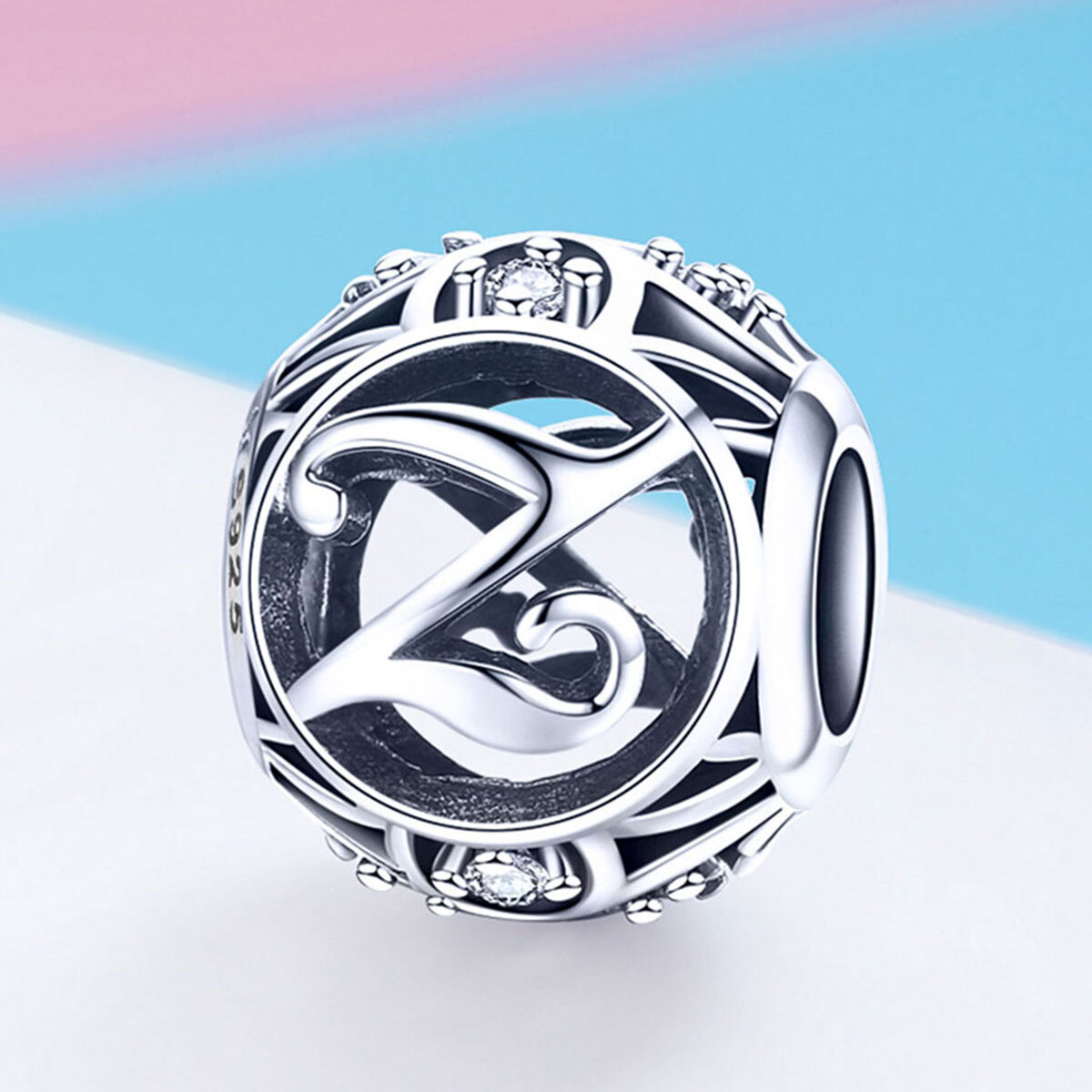Srebrna zawieszka charms z literą Z, ozdobiona drobnymi kamieniami. Widoczny napis \'925\' na boku zawieszki.