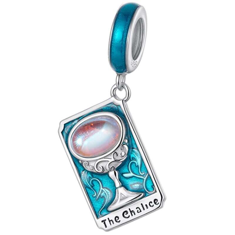 Zawieszka charms w kształcie karty tarota z napisem \'The Chalice\', ozdobiona niebieskim kamieniem i srebrnymi detalami. Element mocujący jest również w kolorze niebieskim.