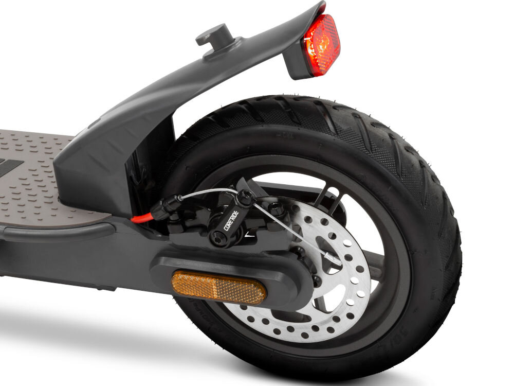 Zdjęcie przedstawia tylne koło hulajnogi elektrycznej z widocznym hamulcem tarczowym i odblaskiem. Na błotniku znajduje się czerwone światło tylne.