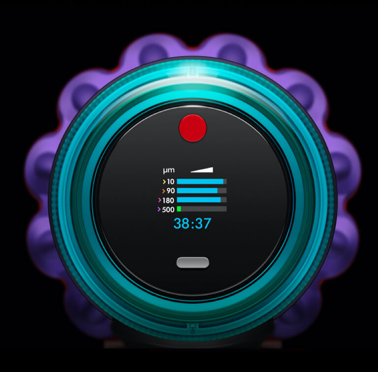 Obraz przedstawia okrągły wyświetlacz z kolorowymi paskami i cyframi \'38:37\'. Na górze widoczny jest czerwony przycisk, a wokół wyświetlacza znajduje się turkusowa obudowa.