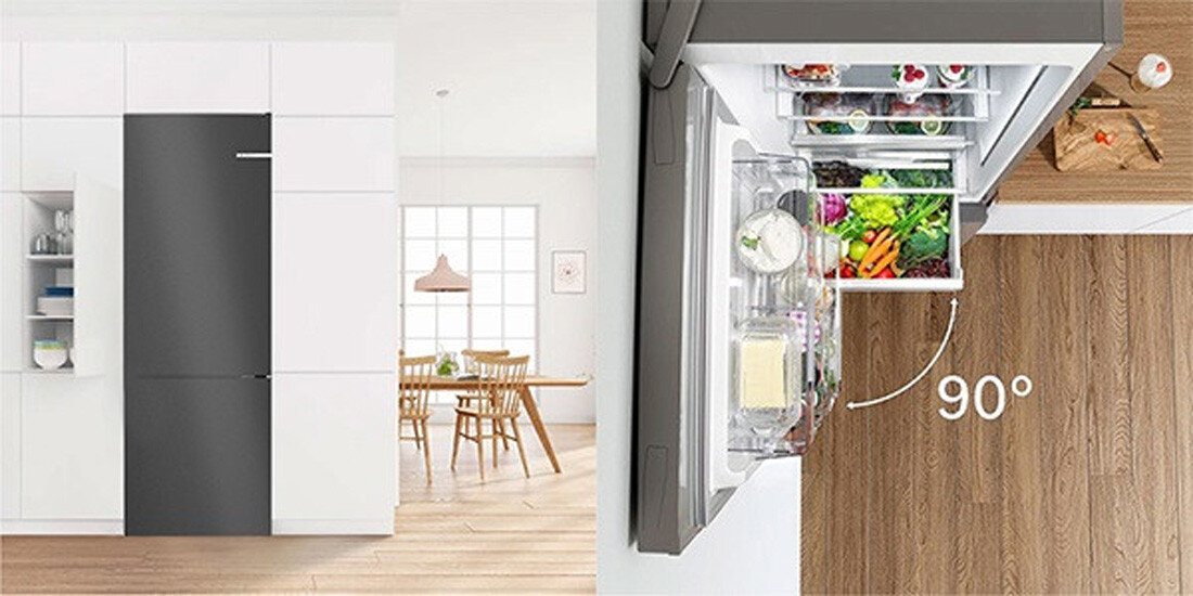 LODÓWKA BOSCH KGN39LBCF BLACK Zdjęcie zestawia widok lodówki w zabudowie kuchennej z obrazem przedstawiającym jej łatwe otwieranie do 90°, ukazanym z perspektywy z góry. Wnętrze chłodziarki wypełnione jest świeżymi produktami, widocznymi po wysunięciu szuflad ustaw przy ścianie swoboda aranżacji PerfectFit