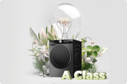 Pralka w kolorze czarnym z widocznym panelem sterowania, otoczona roślinami i dużą żarówką. Na dole widoczny jest napis \'A Class\'.