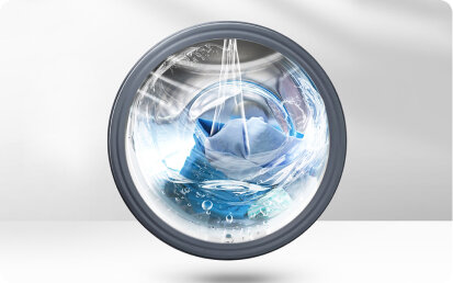 Obraz przedstawia wnętrze bębna pralki z wirującymi ubraniami i wodą. Widać dynamiczny ruch wody i tkanin w bębnie.