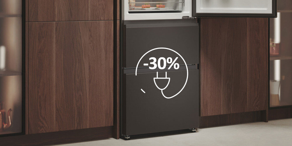 Lodówka w ciemnym kolorze inox z otwartymi drzwiami, ukazująca wnętrze z półkami. Na drzwiach widoczny jest symbol wtyczki z napisem \'-30%\'.