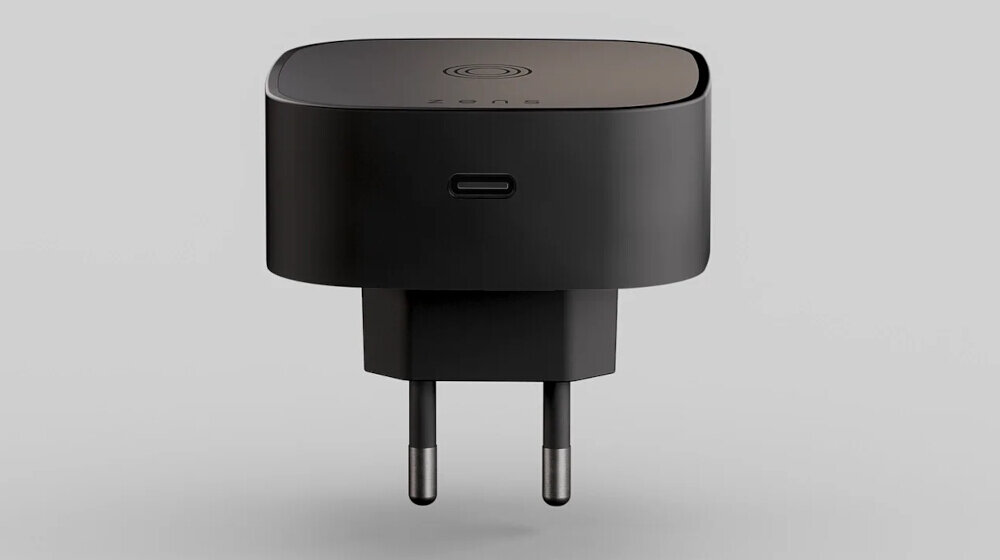 Czarna ładowarka indukcyjna z wtyczką sieciową i portem USB-C na obudowie. Na górnej powierzchni widoczny jest symbol ładowania bezprzewodowego.