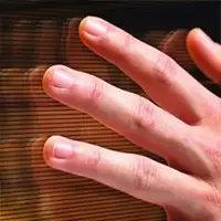 Dłoń dotykająca powierzchnię z poziomymi liniami, prawdopodobnie szklaną lub plastikową.