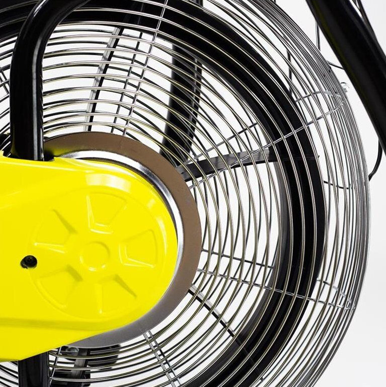 Obraz przedstawia zbliżenie na metalową kratkę wentylatora z żółtym elementem centralnym. Kratka jest częścią urządzenia, prawdopodobnie roweru powietrznego.