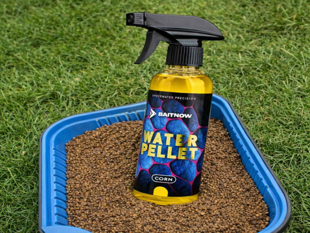 Butelka z rozpylaczem zawierająca płyn o nazwie BAITNOW Water Pellet Corn. Etykieta ma niebieski wzór z tekstem 'UNDERWATER PRECISION' i 'CORN'.