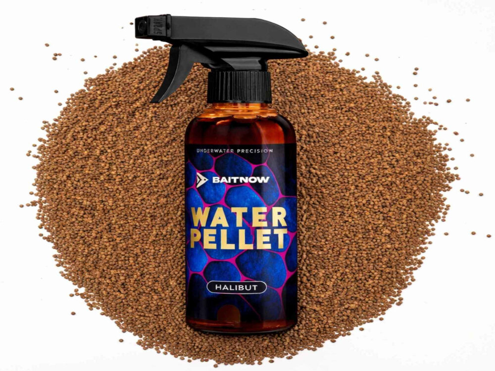 Butelka z atomizerem z etykietą 'BAITNOW WATER PELLET HALIBUT' na tle brązowych granulek. Widoczny tekst: 'UNDERWATER PRECISION'.