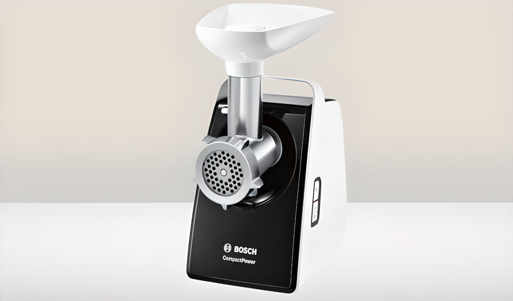 Maszynka do mięsa w kolorze białym z czarnym panelem przednim, na którym widnieje logo BOSCH i napis \'CompactPower\'. Urządzenie posiada metalowy mechanizm mielący i biały podajnik na górze.