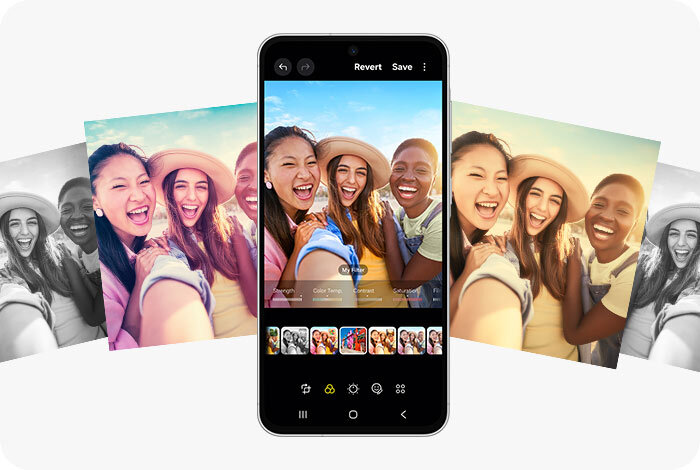 Na obrazie widoczny jest smartfon z wyświetlaczem pokazującym edytowane zdjęcie grupy uśmiechniętych osób. W tle znajdują się różne wersje tego samego zdjęcia z różnymi filtrami kolorystycznymi.