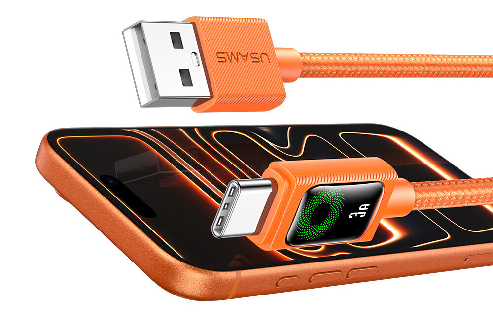 Obraz przedstawia pomarańczowy kabel USB z końcówkami USB-A i USB-C, z widocznym napisem \'USAMS\' na jednej z końcówek. Kabel leży na pomarańczowym telefonie z wyświetlaczem pokazującym abstrakcyjne wzory w kolorze pomarańczowym i czarnym.