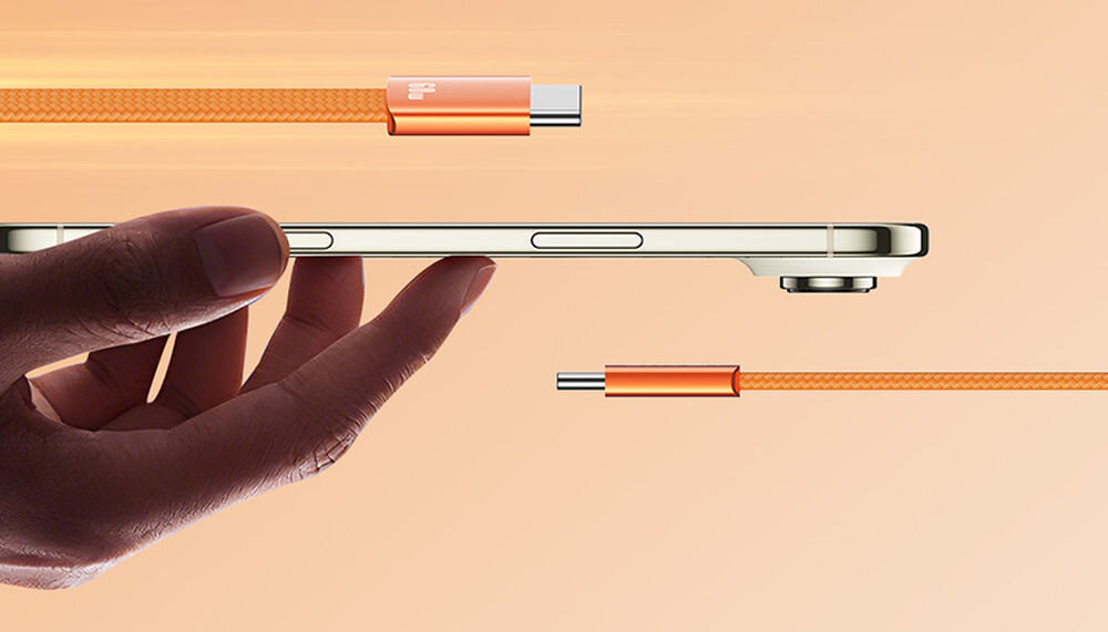 Kabel USB-C - USB-C USAMS U96 60W 1.2 m pomarańczowy, usams u96 pomarańczowy kabel usb c 60w wytrzymaly 1.2m pvc tpu, Dłoń trzymająca smukły telefon obok kabla USB.