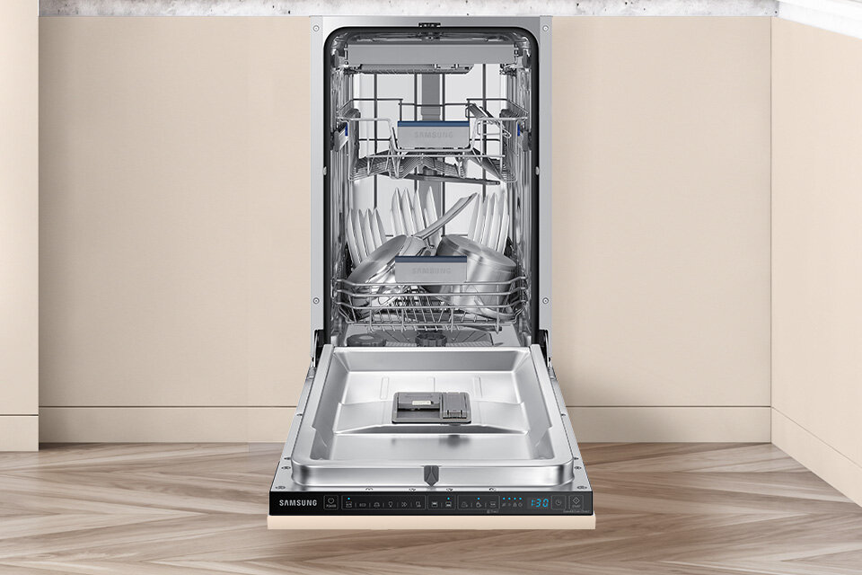 Otwarta zmywarka z widocznymi koszami na naczynia i sztućce. Na panelu sterowania widoczne jest logo \'SAMSUNG\' oraz wyświetlacz z liczbą \'1:30\'.