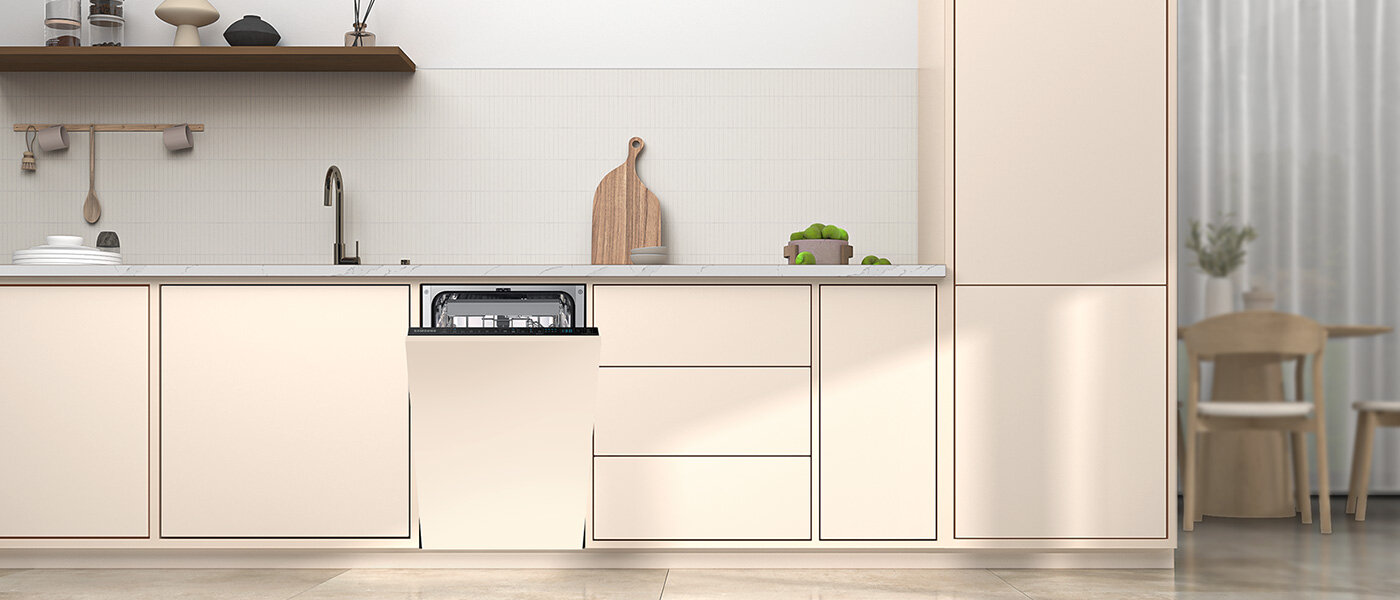 Kuchnia z jasnymi szafkami, w której znajduje się otwarta zmywarka w zabudowie. Na blacie stoją naczynia i deska do krojenia, a w tle widać zasłony i krzesło.