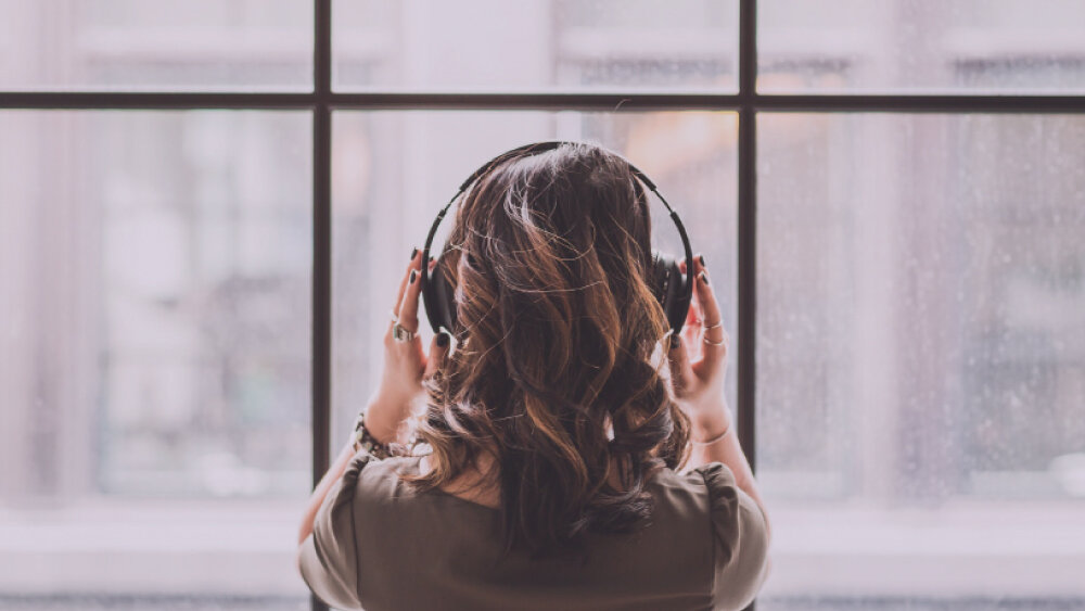 Radioodtwarzacz HYUNDAI TRC985BT - Wyjście słuchawkowe prywatne słuchanie muzyki, osoba z założonymi słuchawkami nausznymi