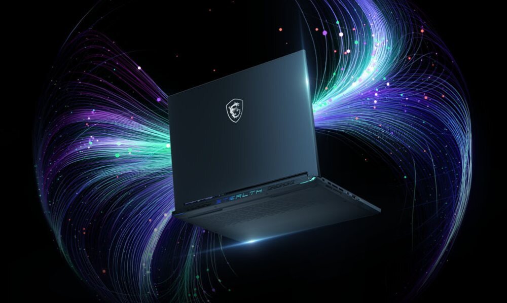 Laptop z widocznym logo producenta na pokrywie, otoczony efektami świetlnymi w kolorach fioletowym i zielonym. Na dolnej krawędzi obudowy widoczny jest napis \'STEALTH\'.