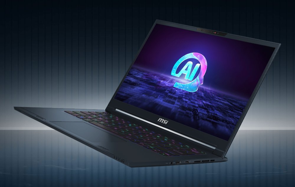 Laptop z logo \'MSI\' na dolnej ramce ekranu, wyświetlający kolorowy symbol \'AI\' na ekranie. Klawiatura podświetlana w różnych kolorach, obudowa w ciemnym odcieniu.