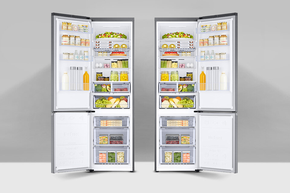 Dwie otwarte lodówki wypełnione różnorodnymi produktami spożywczymi, takimi jak owoce, warzywa, napoje i słoiki. Wnętrze lodówek jest jasno oświetlone, a na drzwiach widoczne są półki z dodatkowymi produktami.