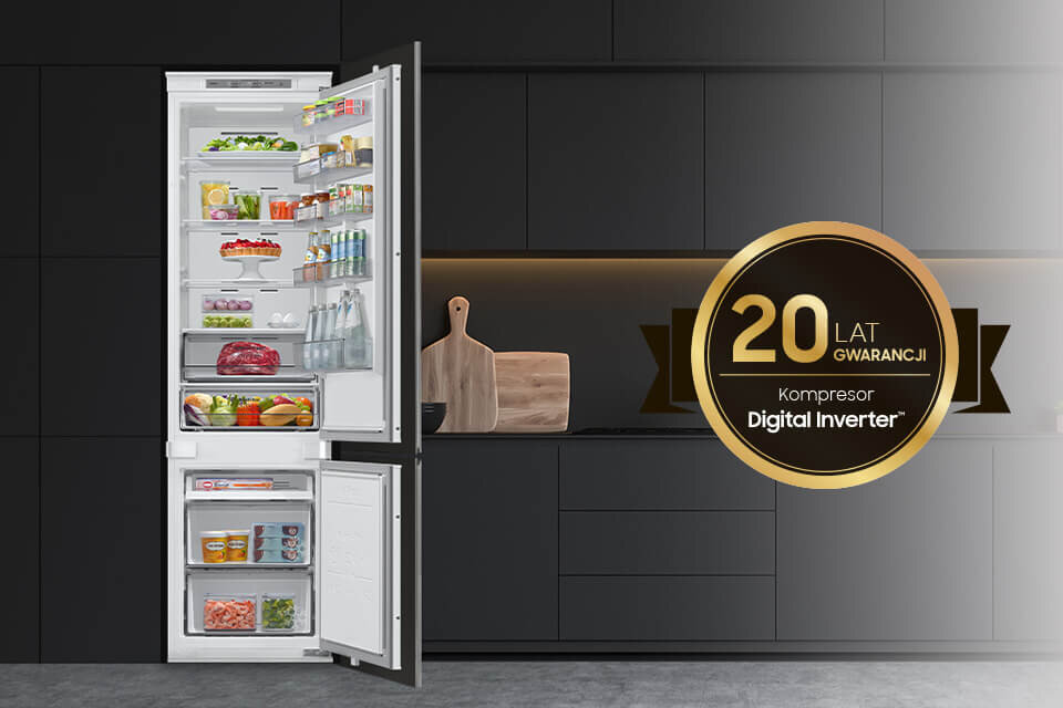 Otwarta lodówka z różnorodnymi produktami spożywczymi, obok której znajduje się okrągły znak z napisem \'20 LAT GWARANCJI Kompresor Digital Inverter\'. W tle widoczna jest ciemna kuchnia z deską do krojenia i nożem.
