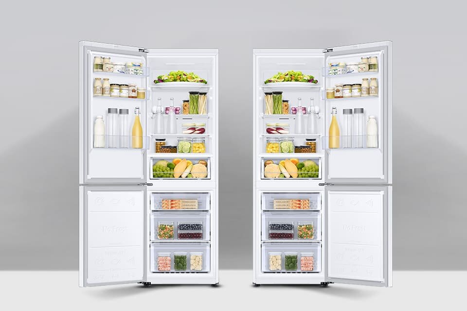 Obraz przedstawia dwie otwarte lodówki z widocznymi półkami wypełnionymi różnymi produktami spożywczymi, takimi jak butelki, słoiki, warzywa i owoce. Lodówki są białe i mają zamrażarki na dole z przezroczystymi szufladami.