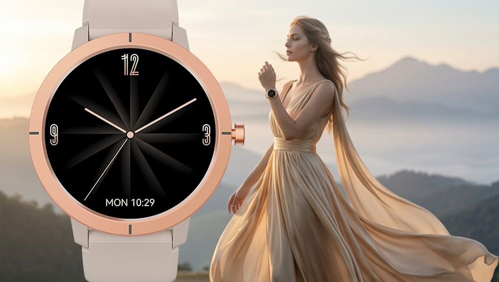 Na obrazie widoczny jest złoty smartwatch z czarną tarczą, na której znajdują się cyfry 12, 3, 6, 9 oraz napis \'MON 10:29\'. W tle znajduje się osoba w długiej, zwiewnej sukni na tle górskiego krajobrazu.