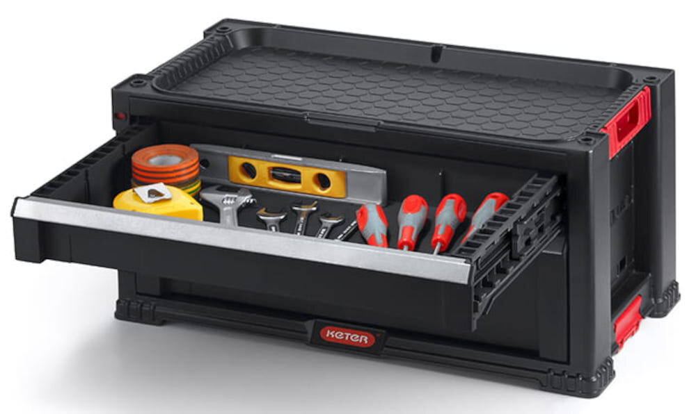 Regał z szufladami KETER 17201228 Czarny białe tło jedna z szuflad otwarta wypełniona narzędziami sześć szuflad jedna głęboka z wyjmowanymi przegródkami cztery mniejsze na drobny sprzęt ochrona przed przemieszczaniem szybki dostęp