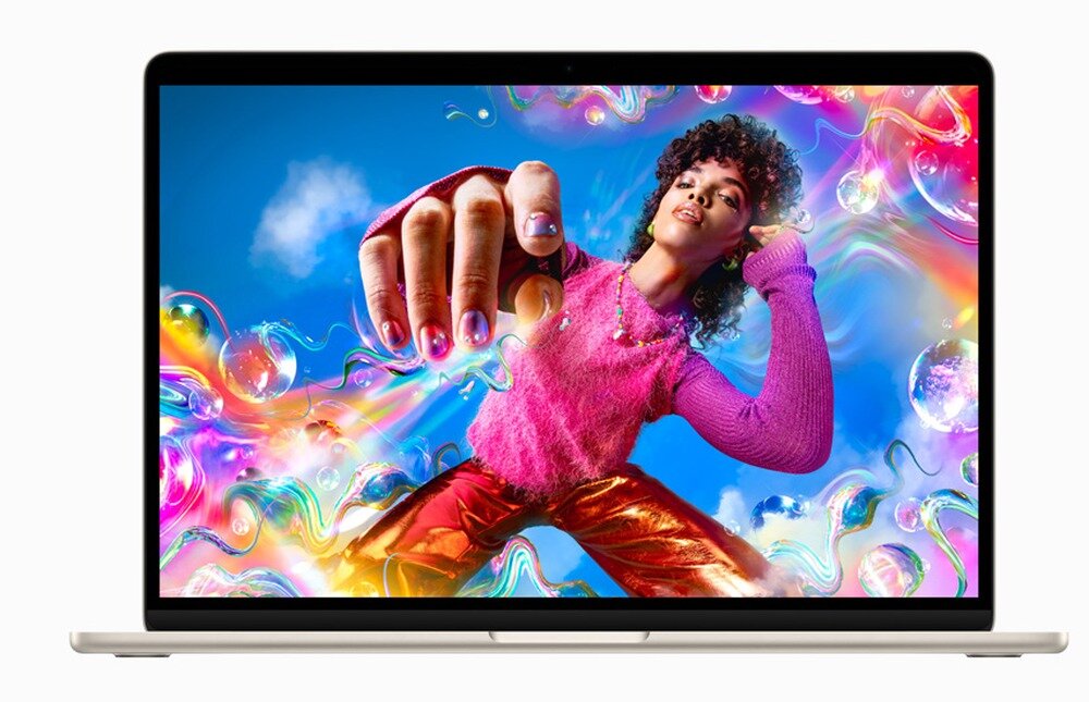 Laptop z wyświetlaczem pokazującym kolorową grafikę z osobą w różowym swetrze i złotych spodniach na tle nieba z chmurami. Obraz jest dynamiczny i pełen kolorowych efektów świetlnych.