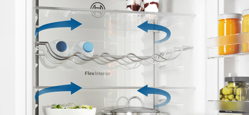 Wnętrze lodówki z półkami, na których znajdują się słoiki i butelki. Widoczne są niebieskie strzałki wskazujące przepływ powietrza oraz napis \'Flex Interior\'.
