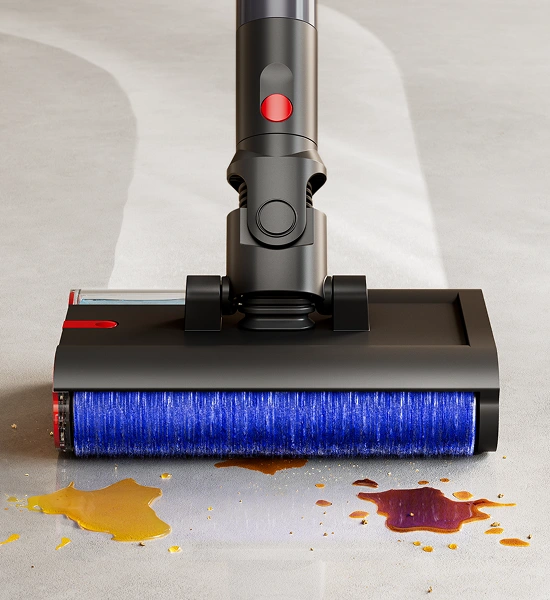 Na obrazie widoczna jest głowica mopa elektrycznego z niebieską szczotką, która zbiera rozlane płyny z podłogi. Mop ma ciemną obudowę z czerwonymi elementami.