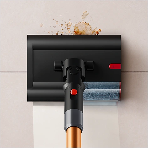 Czarny mop elektryczny z czerwonymi akcentami, czyszczący powierzchnię z rozlaną cieczą. Widoczna jest przezroczysta część z wodą oraz brązowy uchwyt.