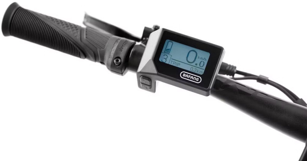Zdjęcie przedstawia kierownicę roweru z wyświetlaczem elektronicznym marki BAFANG, na którym widoczne są dane dotyczące prędkości i dystansu. Obok wyświetlacza znajduje się uchwyt z gumowym chwytem.