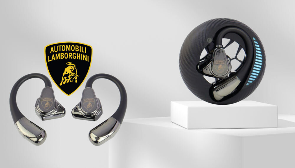 Na obrazie widoczne są czarne słuchawki powietrzne z metalicznymi elementami oraz logo \'AUTOMOBILI LAMBORGHINI\'. Słuchawki prezentowane są na białym postumencie, a obok znajduje się logo producenta.