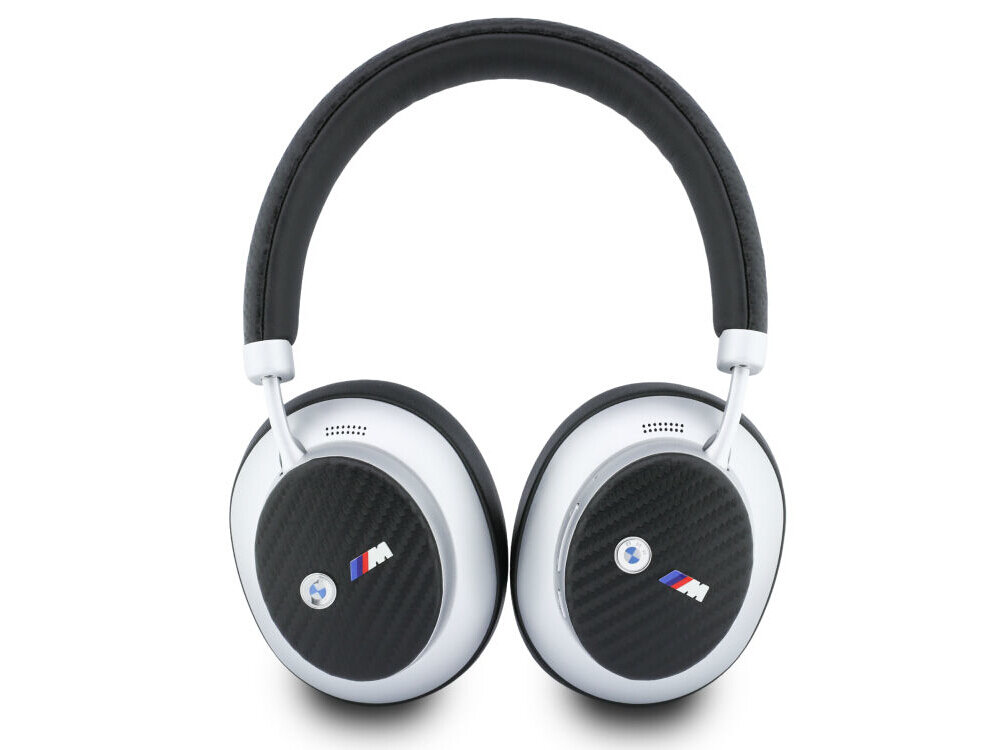 Srebrne słuchawki nauszne z czarnymi nausznikami i logo \'M\' na każdej muszli. Na muszlach widoczne jest również okrągłe logo z niebieskim elementem.