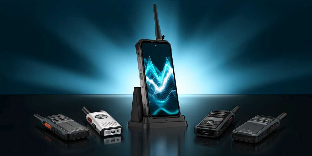 Na obrazie widoczny jest smartfon z dużym ekranem, umieszczony na stojaku, otoczony przez kilka urządzeń przypominających walkie-talkie. Ekran smartfona wyświetla abstrakcyjny wzór w odcieniach niebieskiego.