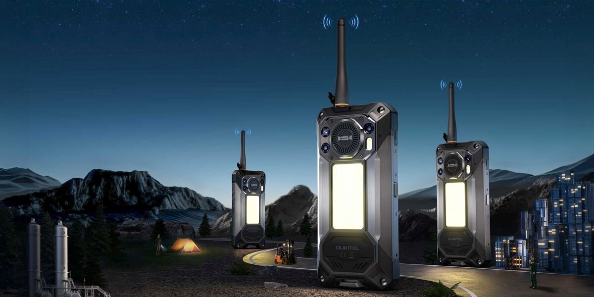 Obraz przedstawia trzy duże urządzenia przypominające smartfony z antenami, umieszczone na tle nocnego krajobrazu z górami i miastem. W tle widoczne są namioty i oświetlone budynki.