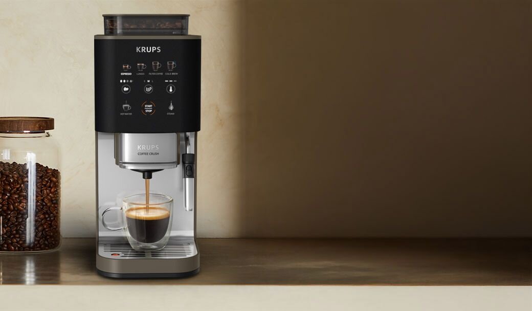 Ekspres do kawy KRUPS Coffee Crush na blacie, obok słoik z ziarnami kawy.