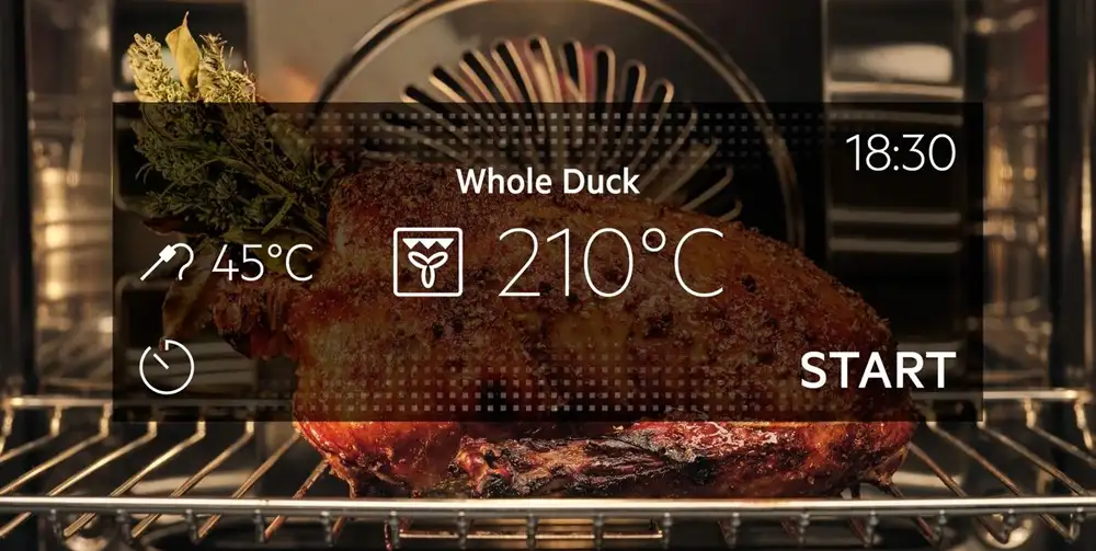 W piekarniku znajduje się pieczona kaczka z ziołami, a na ekranie widoczne są ustawienia: Whole Duck, 45°C, 210°C, 18:30, START.