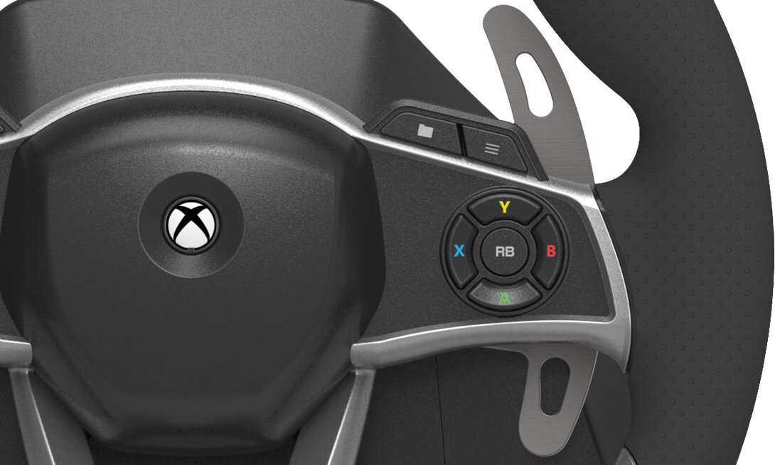 Fragment kierownicy z widocznym logo Xbox na środku oraz przyciskami oznaczonymi literami Y, X, B, A i RB. Kierownica ma metaliczne elementy i perforowaną powierzchnię uchwytu.