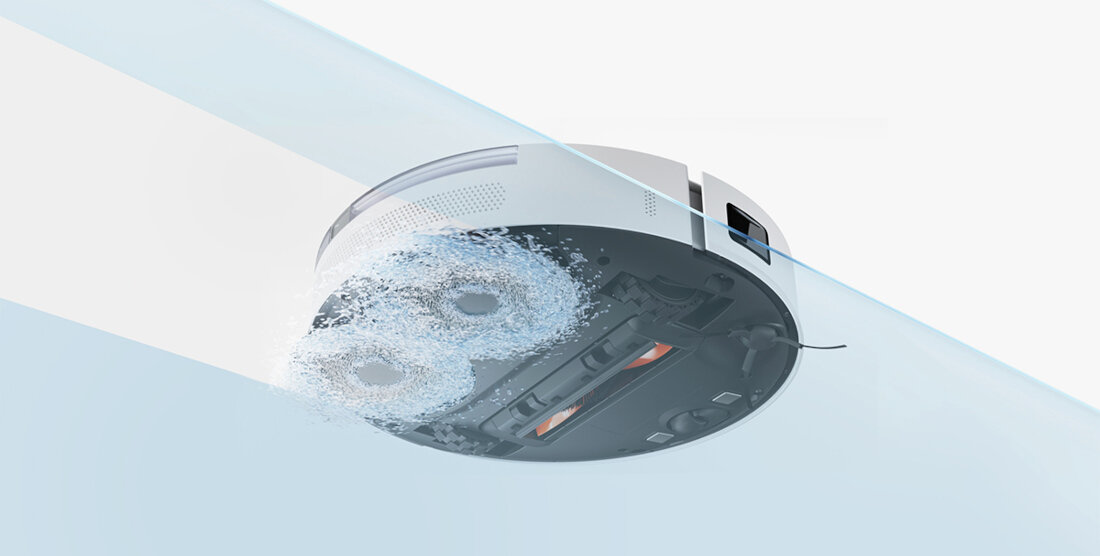 Obraz przedstawia biały robot sprzątający z widocznymi szczotkami i elementami czyszczącymi na spodzie. Robot emituje wodę lub parę, co sugeruje funkcję mopowania.