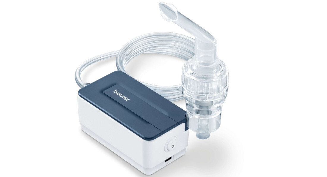 Na zdjęciu widoczny jest inhalator z przezroczystą końcówką i przewodem, obok którego znajduje się prostokątne urządzenie z napisem \'beurer\'.