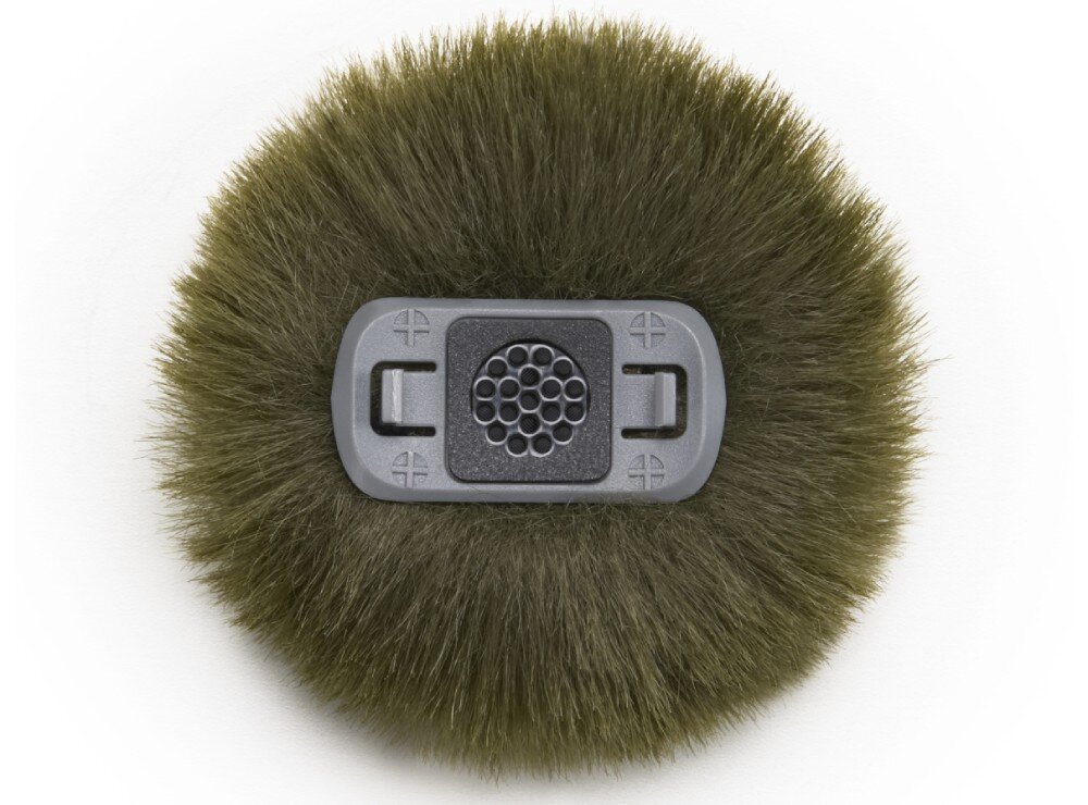 Osłona przeciwwietrzna DJI do Mic Mini 2 (5 szt.) Zbliżenie na dolną część ciemnozielonej osłony przeciwwietrznej z widocznym szarym, plastikowym elementem mocującym wyposażonym w zatrzaski i otwory w centralnej części na tle puszystego materiału, zastosowanie, kolory