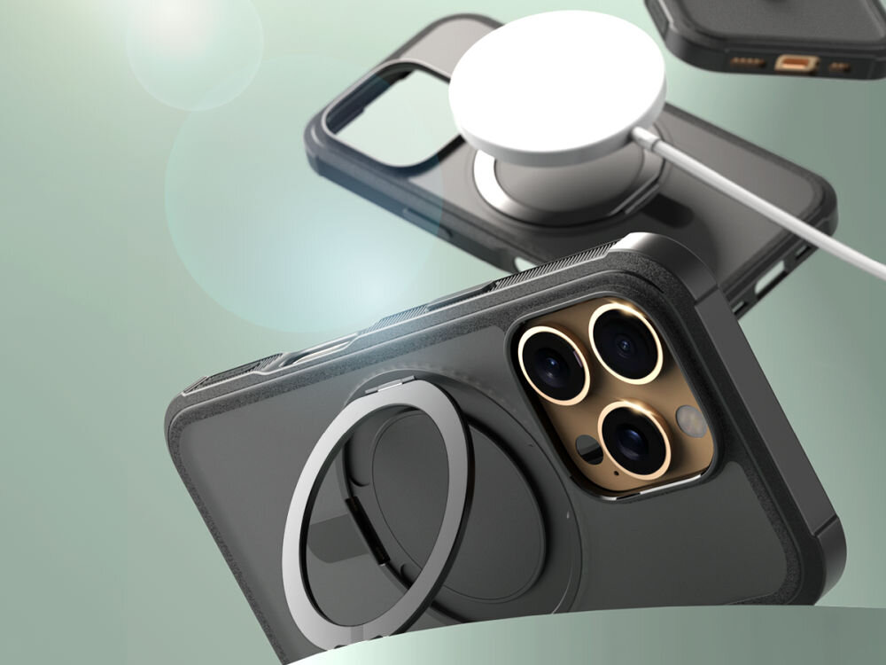 Na obrazie widoczne jest czarne etui z funkcją stojaka MagSafe, przeznaczone do telefonu z trzema obiektywami aparatu. Etui posiada okrągły uchwyt na tylnej części, a w tle widać ładowarkę MagSafe.
