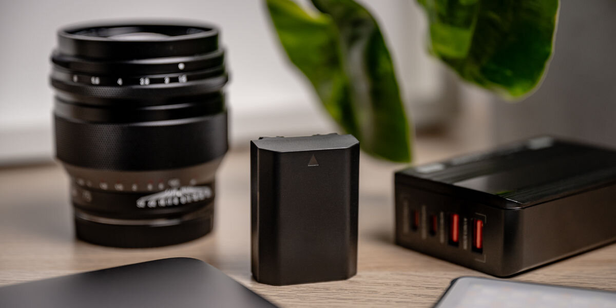 Akumulator NEWELL 2280 mAh do Sony NP-FZ100 Plus, wnętrze, elektronika, użytkowanie, bezpieczne, akumulator stoi na blacie biurka wśród produktów elektronicznych